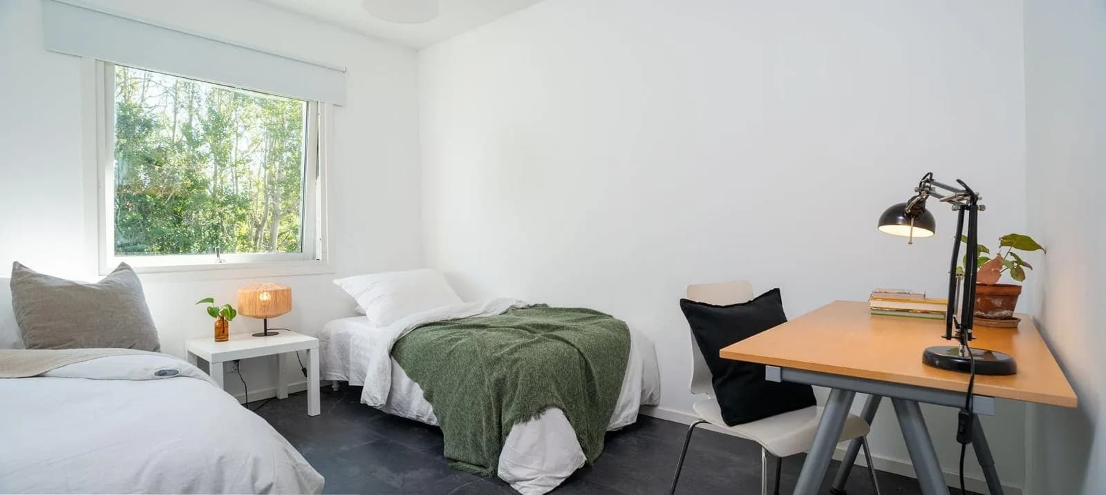 Sovrum med två enkelsängar och skrivbord med arbetslampa